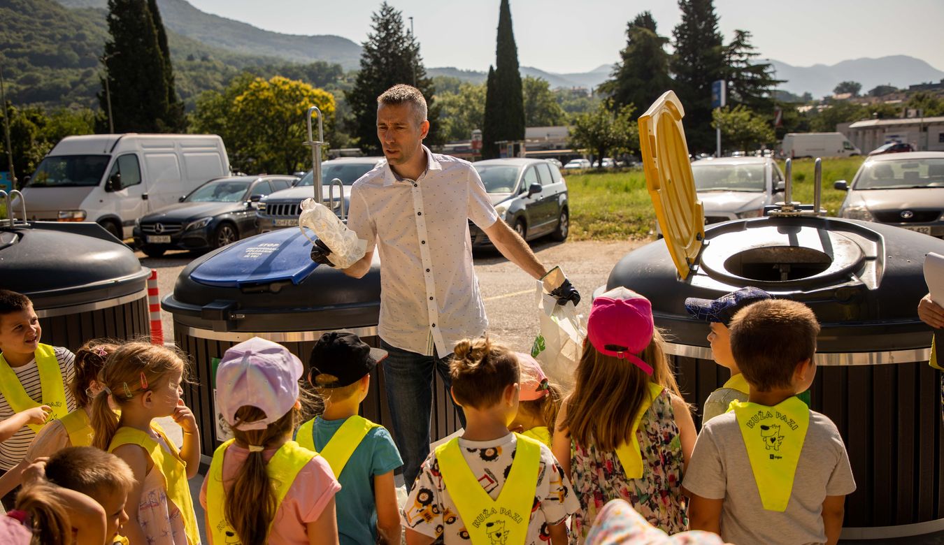 Predstavnik podjetja Komunala Nova Gorica d.d. je skupaj z otroki Vrtca Nova Gorica iz enote Kekec pravilno razvrstil odpadke v nove zabojnike.